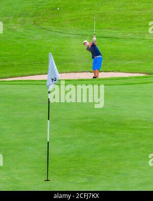 Adolescente su un campo da golf nel Allgäu, giocando a golf in un bellissimo paesaggio. Foto Stock