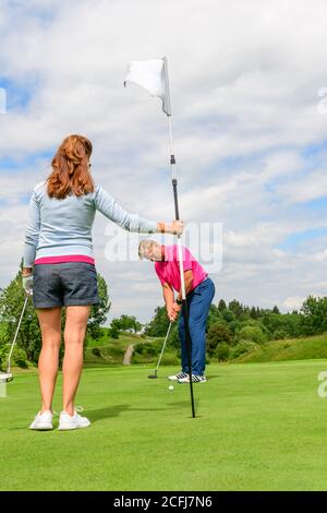 Un gruppo di golfisti su un campo da golf nel Allgäu, giocando a golf in un bellissimo paesaggio. Foto Stock