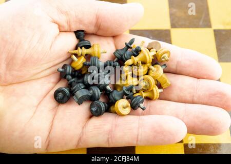 piccoli pezzi di scacchi in legno nella mano degli scacchi lettore Foto Stock