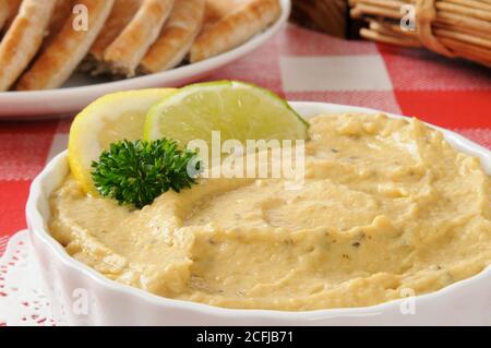 Primo piano di una ciotola di hummus con limone e lime guarnire Foto Stock