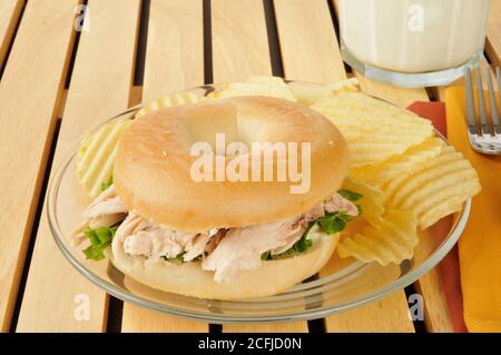 Un sandiwch di pollo su un sacchetto con patatine e. un bicchiere di latte Foto Stock