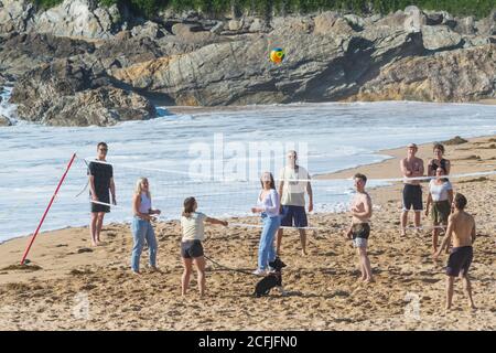 Un gruppo di vacanzieri che gioca una partita di pallavolo sulla spiaggia di Fistral a Newquay in Cornovaglia.