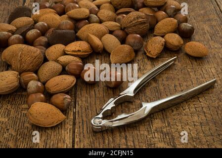 nutcracker e vari noci su fondo tavola di legno Foto Stock