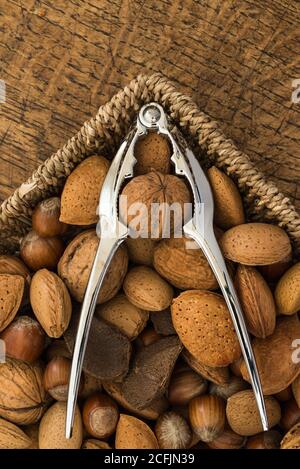 nutcracker e vari noci su fondo tavola di legno Foto Stock