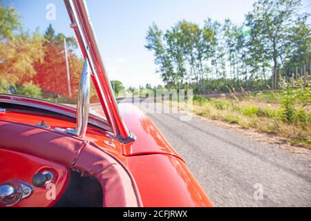 auto sportiva rossa convertibile con la capote in posizione abbassata la strada aperta alla possibilità Foto Stock