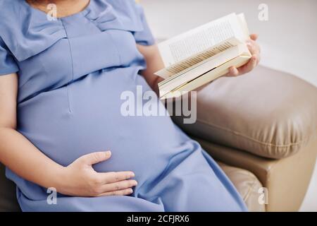 La lettura di donna in stato di gravidanza Foto Stock