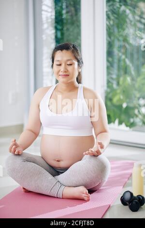 Donna incinta che fa esercizio respiratorio Foto Stock