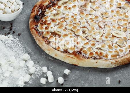 Banana caramellate con pizza spalmata di nocciole. Gli ingredienti sono pasta per pizza, Banana a fette e nocciole spalmate. Dolce e croccante Foto Stock