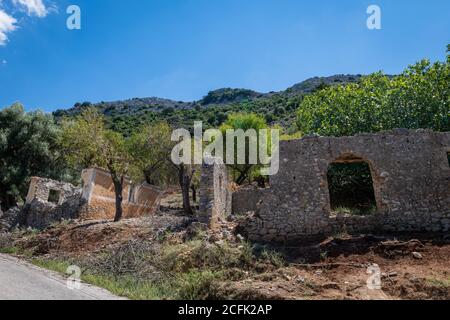 L'insediamento abbandonato Palia Plagia situato su un montianside in Grecia continentale con molte rovine di casa in pietra dereclict. Foto Stock