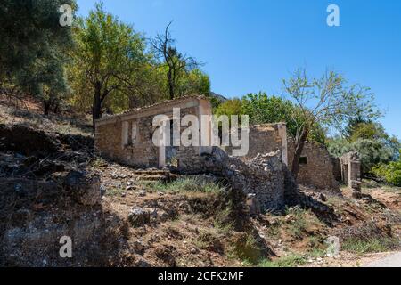 L'insediamento abbandonato Palia Plagia situato su un montianside in Grecia continentale con molte rovine di casa in pietra dereclict. Foto Stock