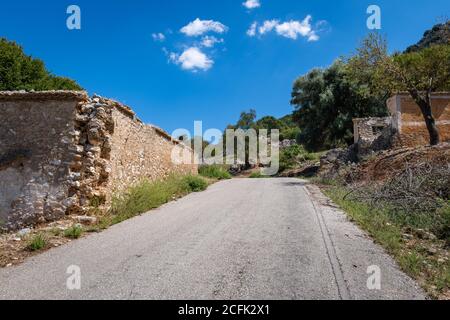 L'insediamento abbandonato Palia Plagia situato su un montianside in Grecia continentale con molte rovine di casa in pietra dereclict. Foto Stock