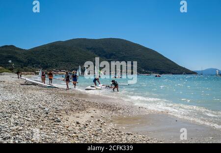 I turisti che amano lo sport del windsurf nelle acque poco profonde della baia di Vasiliki. Foto Stock