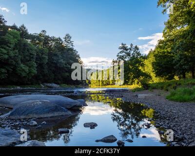 Il fiume Clarion a Cooks Forest state Park in Pennsylvania, a destra prima del tramonto con un cielo morbido che si riflette nel fiume e il sole che si illumina Foto Stock