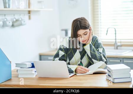 Ragazza adolescente che ha classi in linea a casa Foto Stock