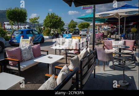 La strada che costeggia il lungomare della località turistica di Nydri, fiancheggiata da ristoranti, bar, caffetterie e negozi per i turisti. Foto Stock