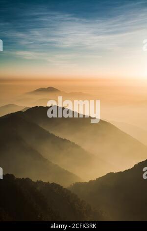 Strati di magnifiche montagne all'alba con nuvole colorate sullo sfondo. Monte Hehuan a Taiwan, Asia. Foto Stock