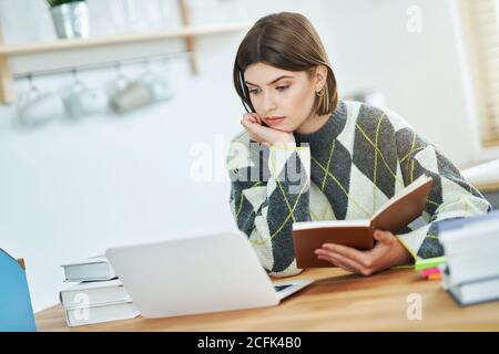 Ragazza adolescente che ha classi in linea a casa Foto Stock