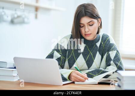 Ragazza adolescente che ha classi in linea a casa Foto Stock