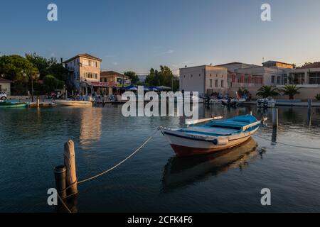 Una vista sulla città di Lefkada, la capitale dell'isola, con edifici e barche che riflettono sulle acque fertane del canale. Foto Stock