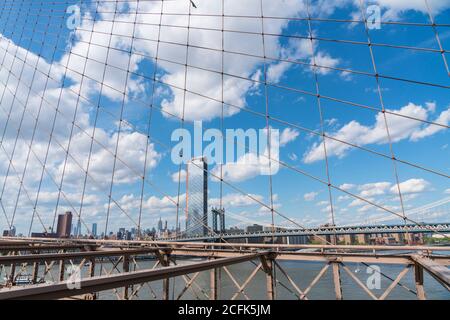 Le nuvole galleggiano nel cielo sulle residenze Lower East Side di Manhattan oltre il Ponte di Brooklyn a New York City NY USA il 16 2029 maggio. Foto Stock
