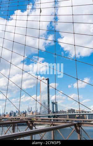 Le nuvole galleggiano nel cielo sulle residenze Lower East Side di Manhattan oltre il Ponte di Brooklyn a New York City NY USA il 16 2029 maggio. Foto Stock