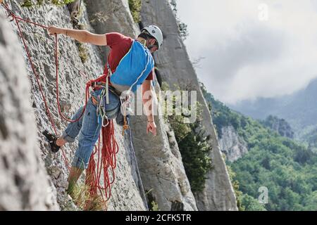 Da sopra di mano di legno con pila di lettere dell'alfabeto su cubi sparsi su sfondo beige in studio Foto Stock