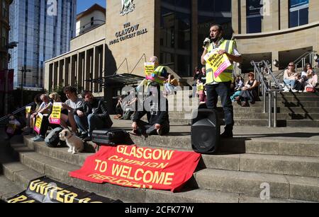 Mohammad Asif (a destra) parla dei passi di Buchanan Street a Glasgow, ai dimostranti che partecipano a un raduno di protesta per i rifugiati Welcome e Black Lives Matter organizzato da Stand Up to Racism Scotland. Foto Stock