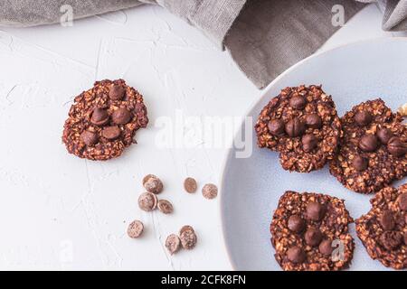 Biscotti appena sfornati alla banana di farina d'avena su un piatto sopra a. lavagna bianca Foto Stock