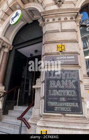 Un ramo della Lloyds Bank situato in Threadneedle Street, la City di Londra, con un vecchio targa accanto all'entrata. Foto Stock