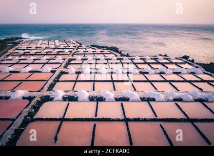 Foto aerea del paesaggio di incredibili stagni di sale rosa situato vicino piccola costa sulla spiaggia Foto Stock