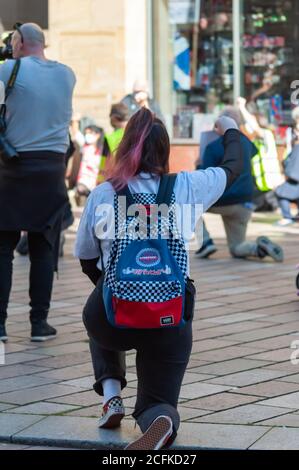 Glasgow, Scozia, Regno Unito. 6 settembre 2020: I dimostranti prendono il ginocchio in una manifestazione contro il razzismo, organizzata da Stand Up to Racism sulla via Buchanan passi che chiedono di porre fine all'ambiente ostile e alle politiche di detenzione illegale e di accogliere i rifugiati e di sostenere la questione Black Lives. Credito: SKULLY/Alamy Live News Foto Stock