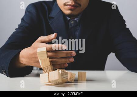 Mani di imprenditore uomo d'affari che tiene blocchi di legno che mettono ad una struttura, concetto di lavoro di squadra, strategia, lavoro professionale di manager per executiv Foto Stock