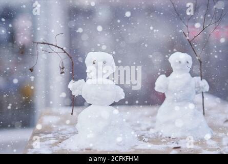 Due piccoli pupazzo di neve carino con rami invece di mani sfondo di Natale nuovo anno umore. Foto Stock