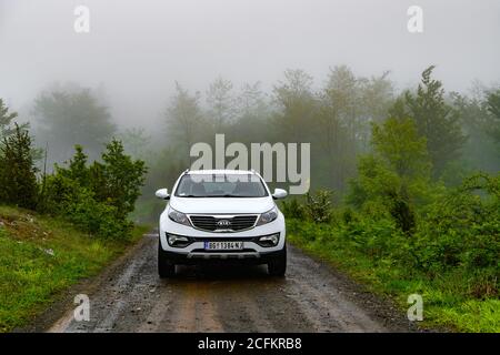 SUV Kia Sportage 2.0 CRDI awd o 4x4, mattina presto sulla strada di montagna dirth, bellissimo paesaggio auto. Test incrociati su terreni duri. Strada pericolosa Foto Stock