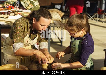 Moldavanskoye, Krymsk, Russia-05 Ottobre 2019: Un vasaio insegna ad una ragazza come fare una caraffa di argilla. Master class al festival del vino giovane di Lefka Foto Stock