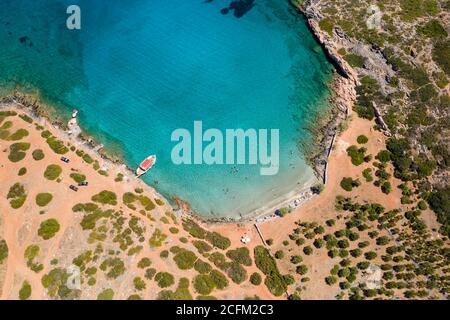 Vista aerea del drone di una piccola spiaggia su una costa rocciosa e arida e oceano cristallino (Kolokitha, Creta, Grecia) Foto Stock