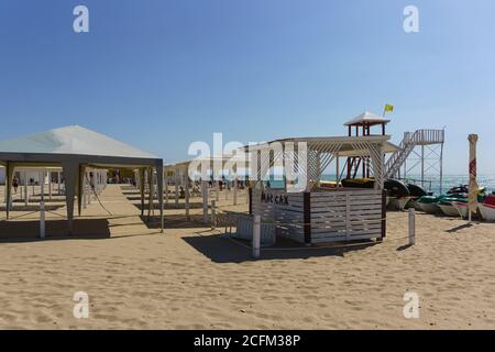 YevPatria, Crimea, Russia-12 settembre 2019: Visite ombra sulla spiaggia sabbiosa 'Novy' nella località turistica. Testo russo " Massaggio" Foto Stock