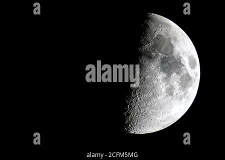 Mezza luna su un cielo notturno, dove si possono vedere i crateri Foto Stock