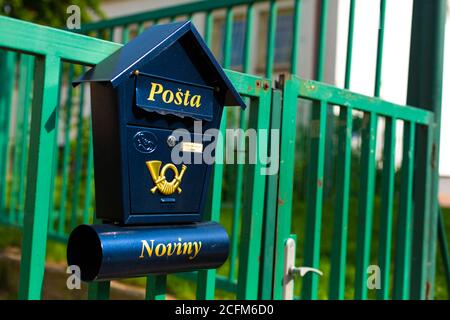 Casella postale blu elegante sullo sfondo di una recinzione verde nella Repubblica Ceca. Foto Stock