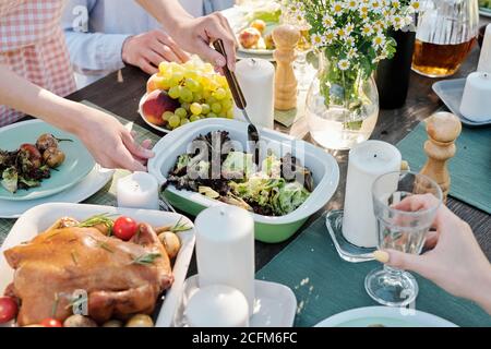 Mani di giovane femmina con presa del cucchiaio o mescolando cotti verdure sul tavolo Foto Stock