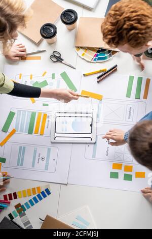 Vista dall'alto di diversi sviluppatori creativi professionisti che discutono di schizzi Foto Stock