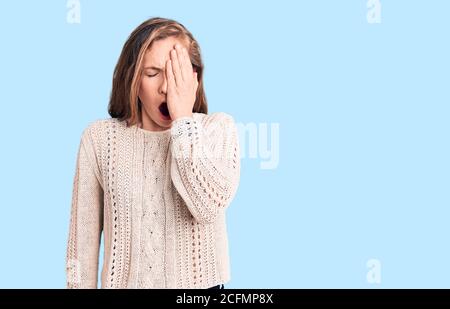 Giovane bella donna bionda che indossa un maglione casual stanco che copre metà faccia, occhio e bocca con la mano. Faccia fa male nel dolore. Foto Stock