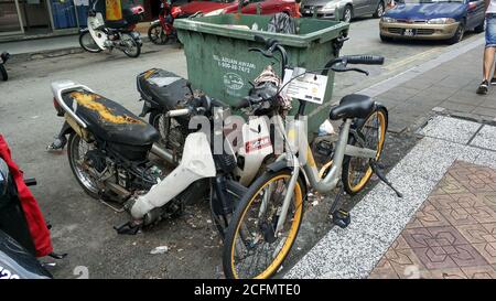 Una bicicletta abbandonata semi-smantellata su una strada cittadina. Trasporto in Asia Foto Stock