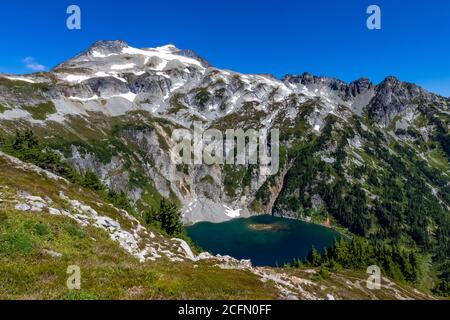 Il lago Doubtful, con il monte Sahale e il Boston Peak che torreggiano sopra, si vede dal sentiero per Sahale Arm, North Cascades National Park, Washington Stat Foto Stock