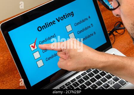 Persona che vota sul computer tramite Internet con testo votazione online Foto Stock