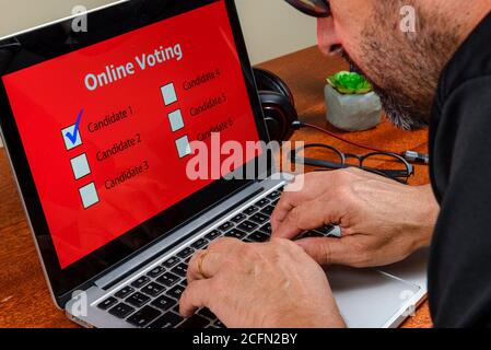 Persona che vota sul computer tramite Internet con testo votazione online Foto Stock