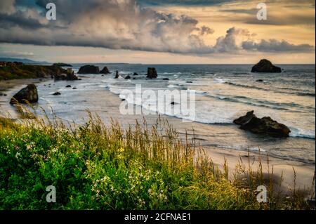 Tempesta drammatica nuvole sulla spiaggia con le pile di mare in Oregon, Stati Uniti Foto Stock