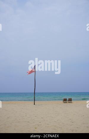 Bandiera della Malesia che svetta sulla spiaggia dell'isola di Tioman durante il caldo pomeriggio. Foto Stock