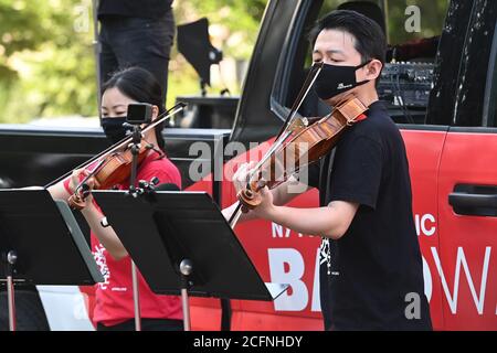 Il violinista Filarmonico di New York Quan GE e l'assistente principale viola Cong Wu si esibiscono fuori dall'ingresso dei Giardini Botanici di Brooklyn come parte dei concerti pop-up dei carri a bandwagon di NY Phil nel quartiere Brooklyn di New York, NY, 6 settembre 2020. Con i locali di musica ancora chiusi a causa delle restrizioni pandemiche della COVID-19, la New York Philharmonic ha creato uno spettacolo "pull-up" in tutti i cinque quartieri di New York City, ma non fornisce alcun preavviso per ridurre al minimo le dimensioni della folla e il rischio di diffondere il coronavirus. (Anthony Behar/Sipa USA) Foto Stock