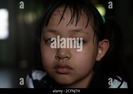 Bambina asiatica che guarda in su e pensa con solo E stile chiave tristezza.bassa Foto Stock